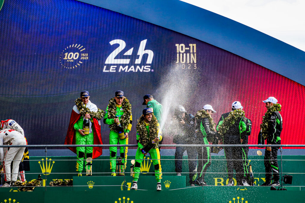Podium 24h Le Mans 2023 w klasie LMP2. Na pierwszym planie Śmiechowski (POL), Scherer (SUI) i Costa (ESP).